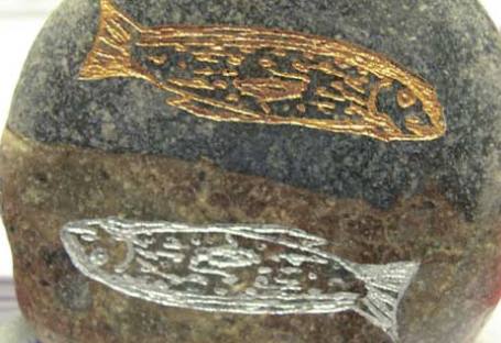 гравированное изображение рыб на камне
